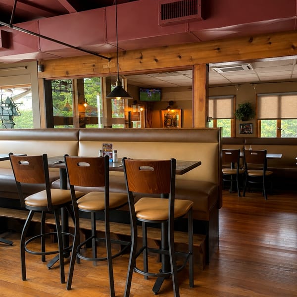 Charlie's Place booth and high-top seating with warm wood tones and TVs.